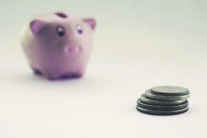 貯金箱と積み重ねた硬貨（貯蓄・資産形成）